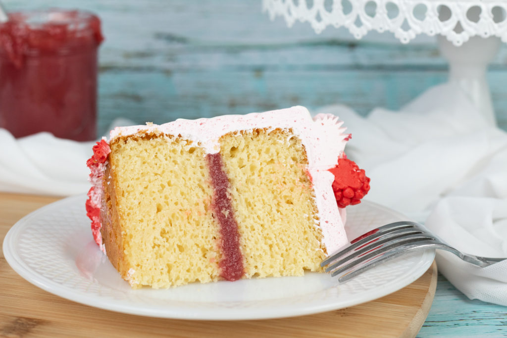 A delicious piece of cake with raspberry filling.